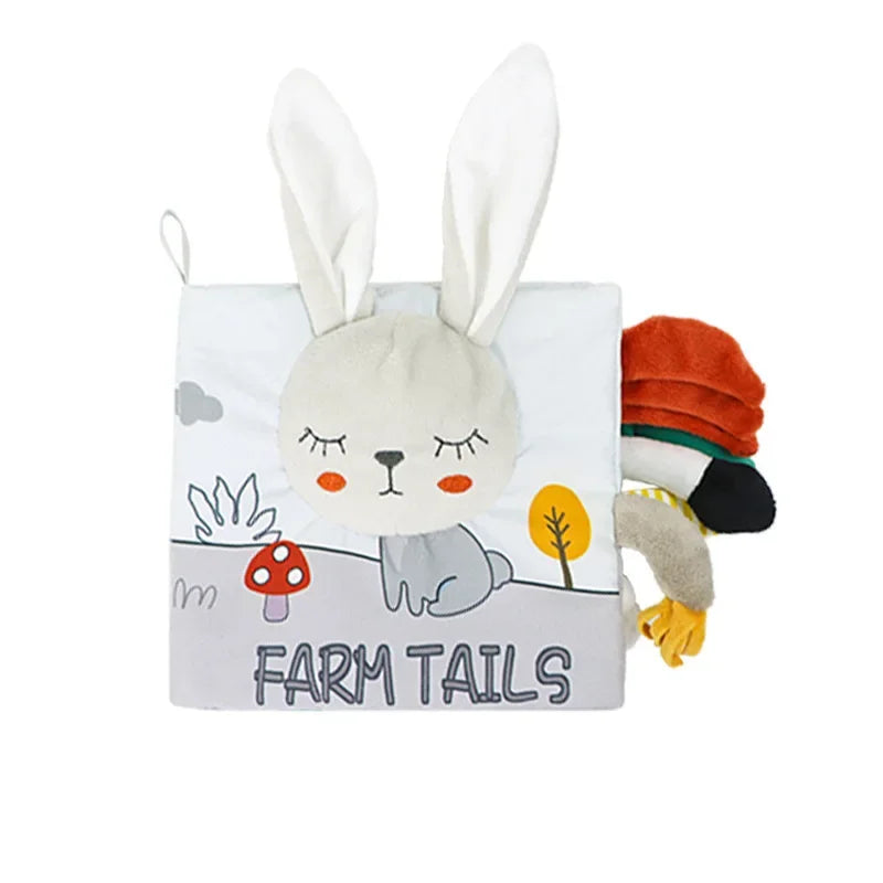 Soft fabric children's book titled "Farm Tails" with a bunny face and ears on the cover. It features colorful farm-themed imagery and textured animal tails poking out.