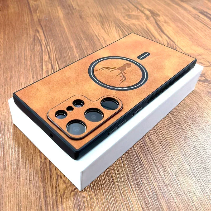 Smartphone on a box with a brown leather case, featuring a camera setup and a round embossed design of an octopus. The background is a wooden surface.