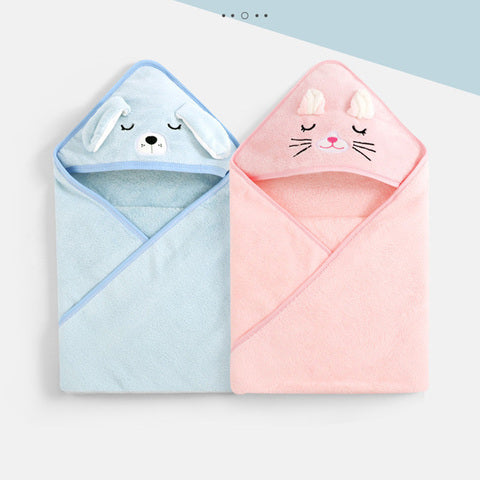 Two hooded baby towels, one blue with a dog design and floppy ears, the other pink with a cat face and whiskers, displayed side by side on a light background.