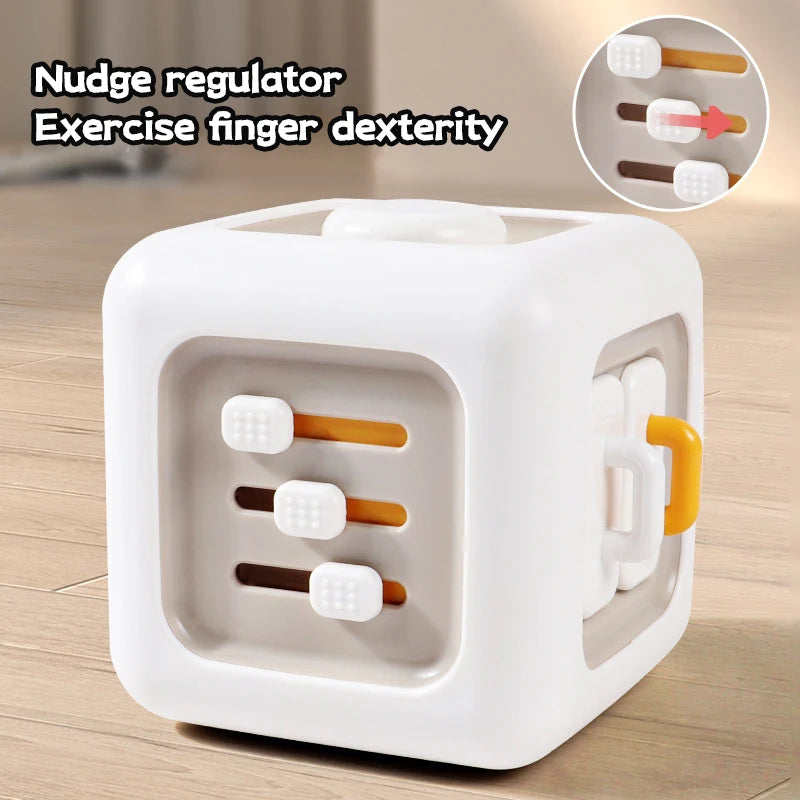White cube fidget toy on a table with sliders for finger dexterity exercises. Text reads, "Nudge regulator, Exercise finger dexterity," with a close-up of sliders.