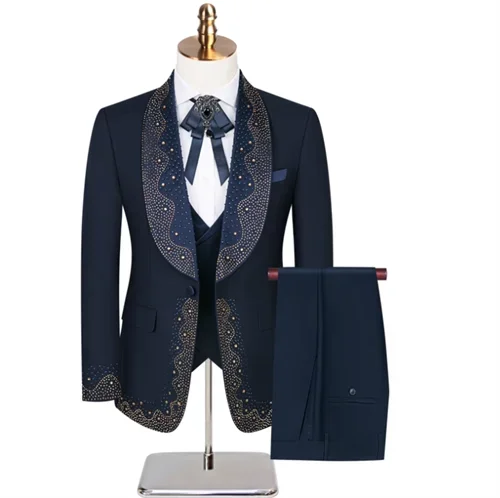 Elegant navy blue tuxedo on a mannequin, featuring an ornate patterned shawl collar and cuffs, paired with matching pants. The ensemble includes a white shirt and decorative tie.