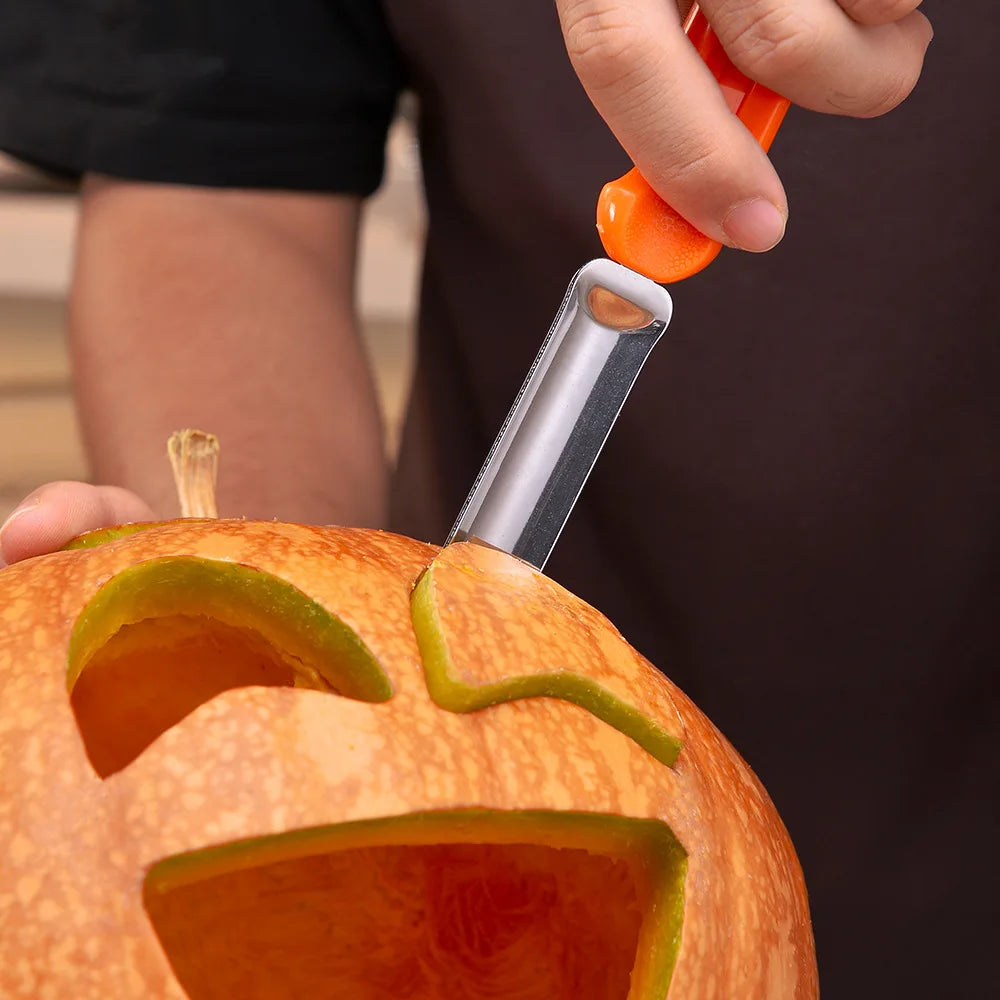 Close-up of a person carving a jack-o'-lantern face into an orange pumpkin using a carving tool with an orange handle.