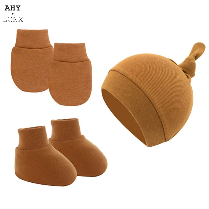 Brown baby accessory set featuring a hat with a knot, matching mittens, and booties, made from a soft, knitted fabric.
