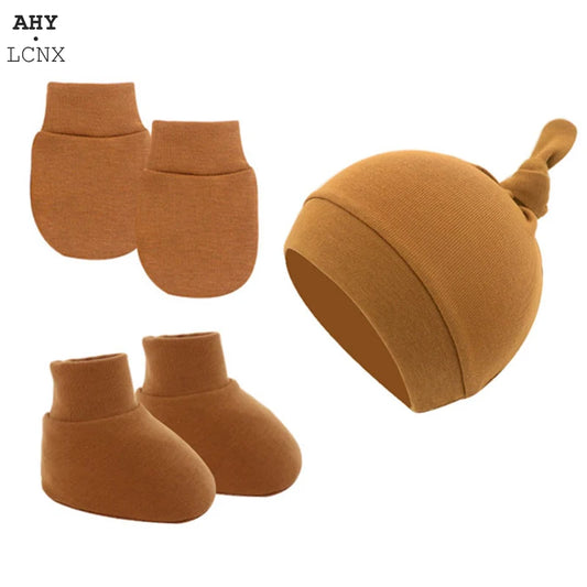 Brown baby accessory set featuring a hat with a knot, matching mittens, and booties, made from a soft, knitted fabric.