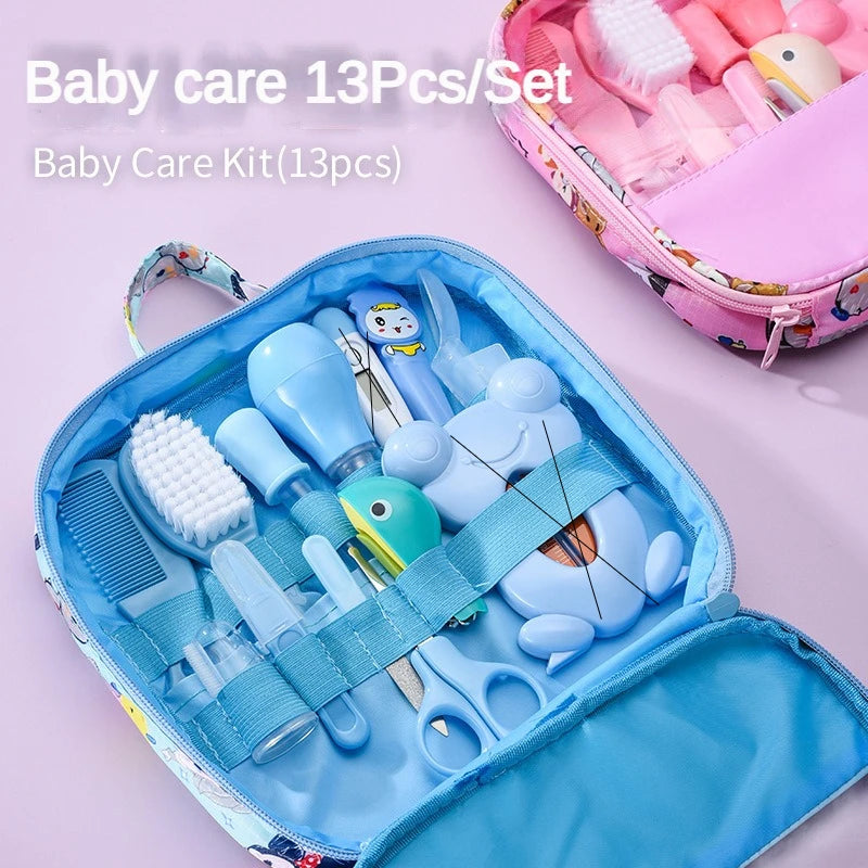 Blue and pink baby care kits with 13 pieces each, including brushes, combs, scissors, and additional baby essentials, neatly organized in zippered cases.