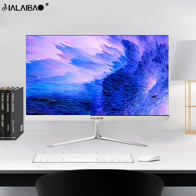 A sleek computer monitor with a vibrant abstract blue and purple display on a modern desk. Nearby are closed books, a keyboard, a mouse, and a lamp.