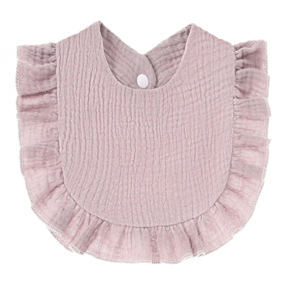 Pink ruffled baby bib with textured fabric and snap closure at the back.