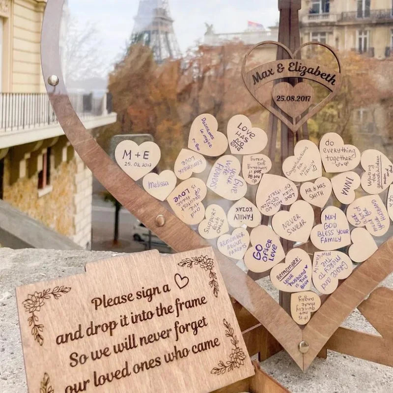 A heart-shaped sign with messages and names on wooden hearts commemorates Max and Elizabeth's wedding on 25.08.2017. A nearby wooden plaque invites guests to sign and remember.