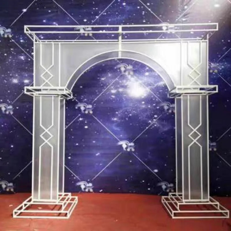 Metal arch frame with decorative geometric patterns stands on a red carpet against a starry night backdrop, creating a visually striking contrast.