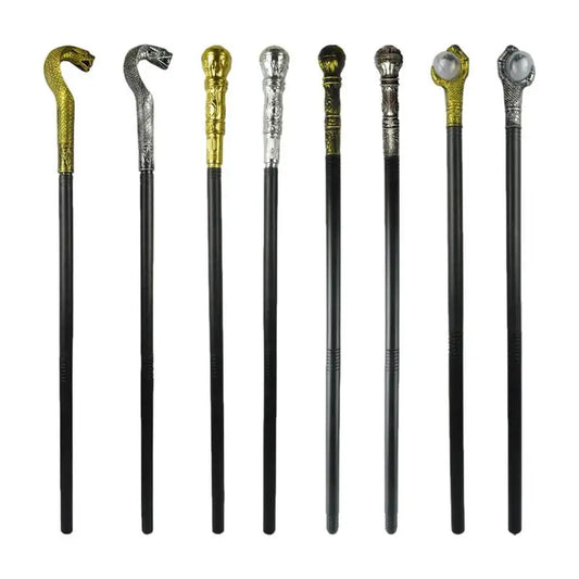 A collection of eight black walking canes with ornate metallic handles in various designs, including silver and gold snakes, domed caps, and intricate patterns.