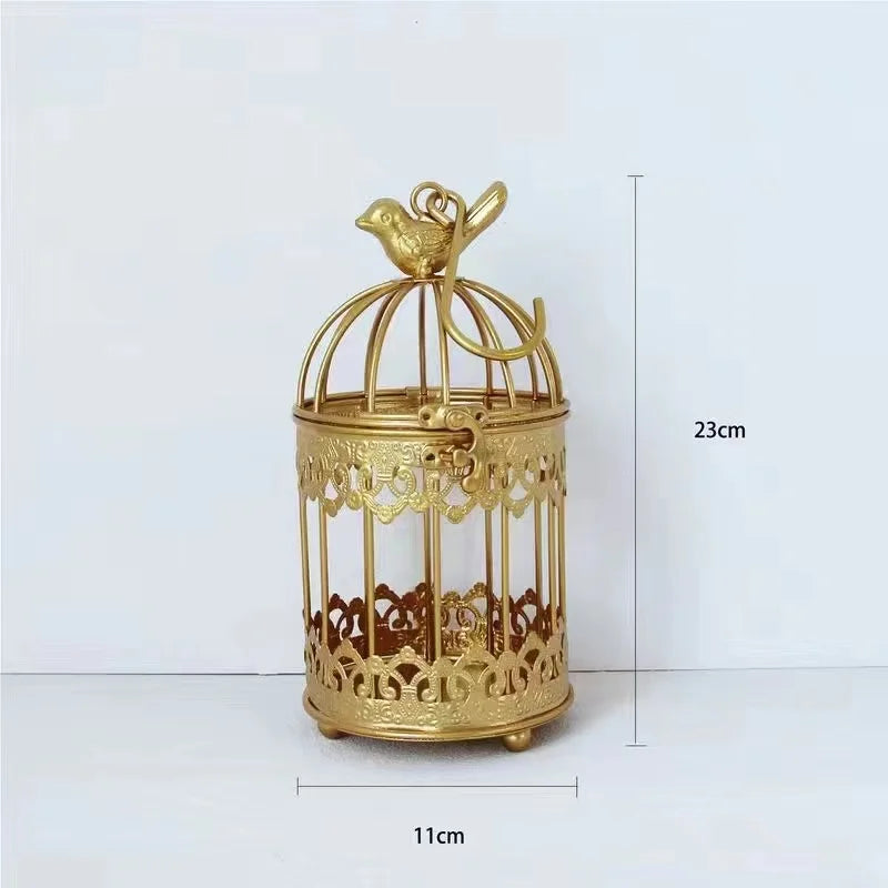 A decorative 23cm tall, 11cm wide gold birdcage with ornate detailing and a small bird figurine on top, set against a plain white background.