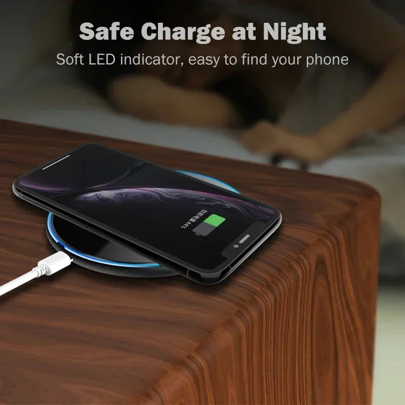 Smartphone charging wirelessly on a bedside table with a glowing LED pad, text reads "Safe Charge at Night. Soft LED indicator, easy to find your phone," with a blurred sleeping figure.