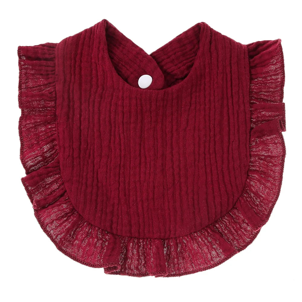 Red baby bib with a textured fabric design, featuring ruffled edges and a white snap fastener at the neck.