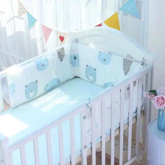 White crib with light blue bedding and bear-patterned bumpers. Colorful bunting and pink flowers in a blue vase are visible nearby, with soft light filtering through curtains.