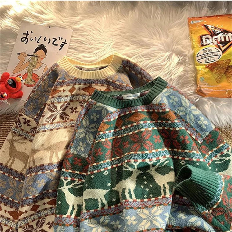 Two patterned sweaters with deer and snowflake designs, one in beige tones and the other in green and red, are laid on a fluffy rug. Nearby are a Doritos bag, a postcard, and toys.