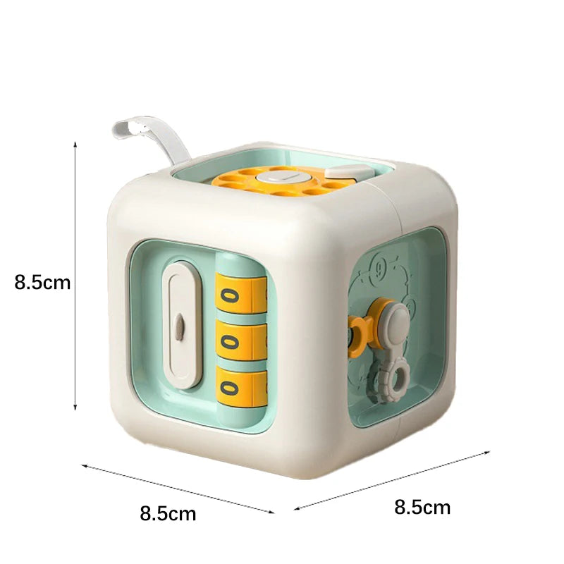 Interactive toy cube measuring 8.5cm x 8.5cm x 8.5cm. Features include a yellow gear, dials, and buttons with a light blue and white design, ideal for children's play and development.