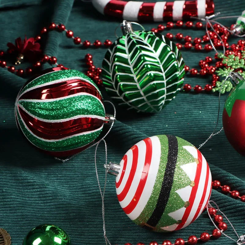 Festive Christmas ornaments with stripes and patterns in red, green, and white on a dark green cloth, surrounded by red beads and a candy cane decoration.