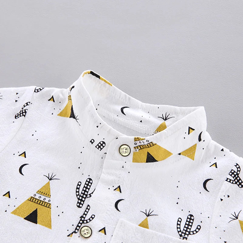 White button-up shirt with a stand collar, featuring yellow teepee and black cactus patterns, along with scattered black crescents and triangles.
