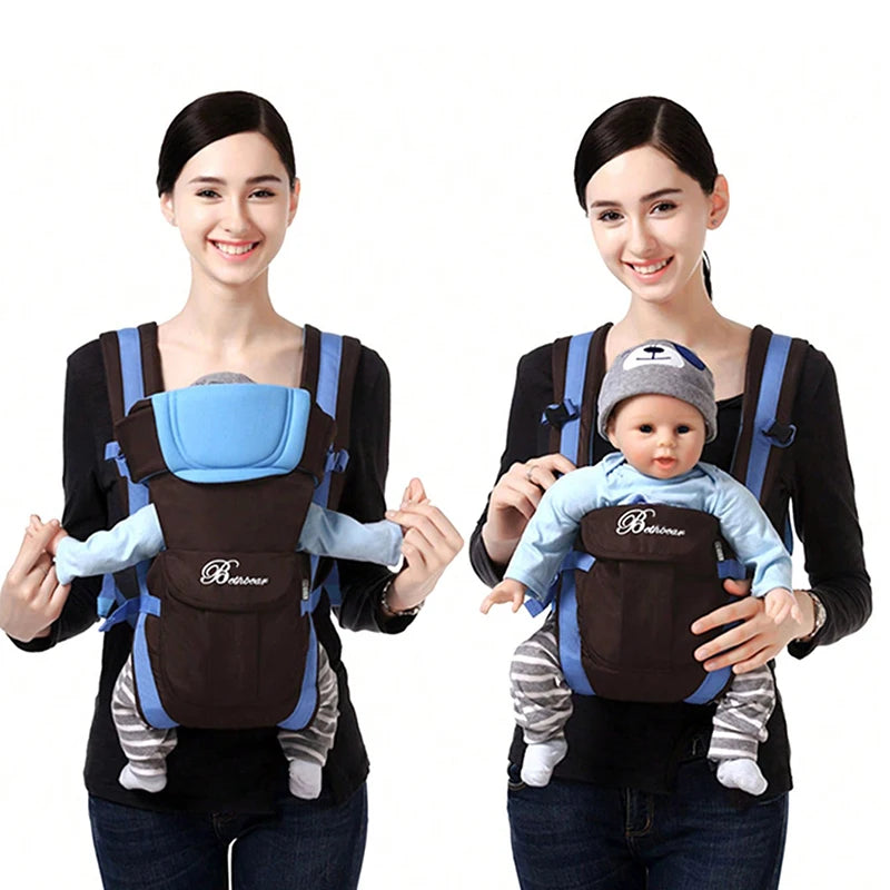 Two women each wearing a blue and black baby carrier. One carrier holds a baby facing forward, the other shows a baby facing inward. Both women are smiling.