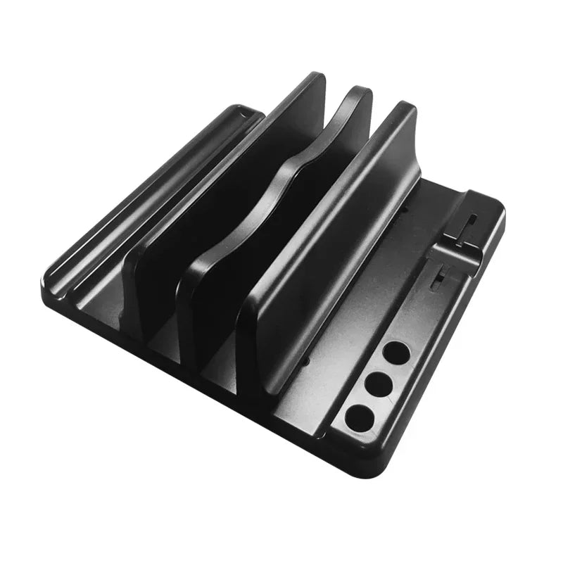 A black metal device organizer with three vertical slots for holding items. The base includes circular cable management holes and a flat area for small accessories.