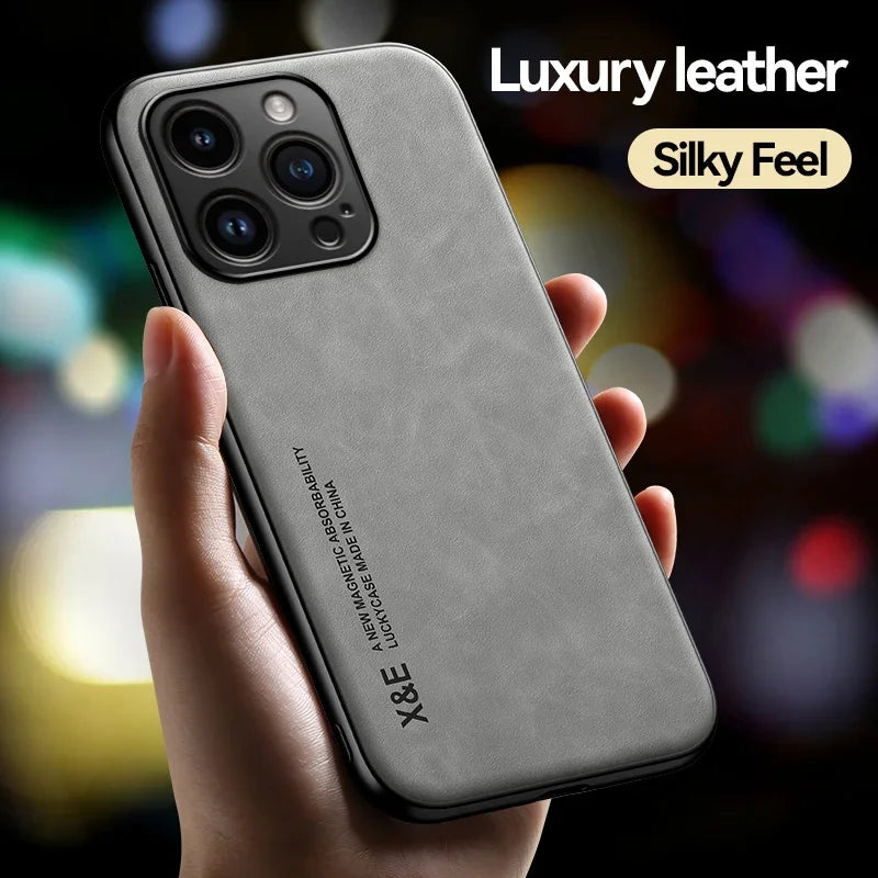 Person holding a smartphone with a gray luxury leather case featuring three camera lenses. Text reads "Luxury leather," "Silky Feel," and "X&E" on the case. Blurred background.