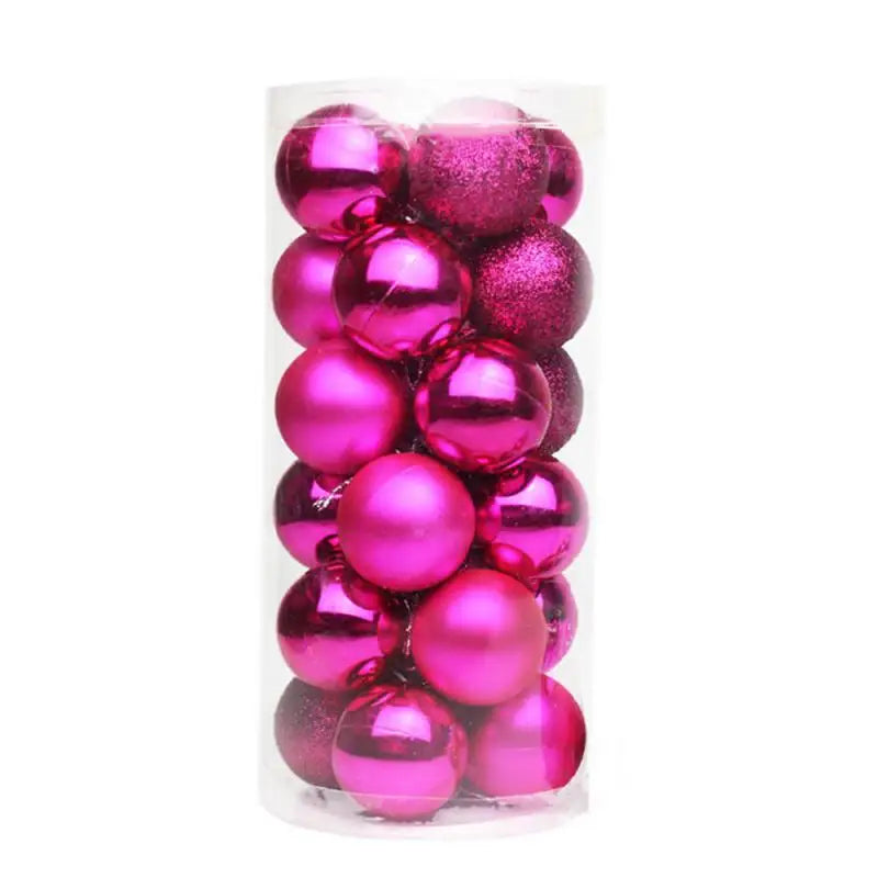 A clear cylindrical container filled with shiny and matte pink Christmas ornaments, including some with glitter, against a plain white background.