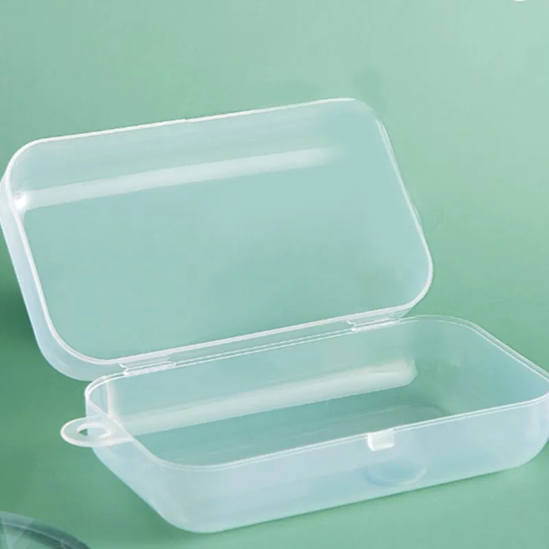 Open transparent plastic storage case on a light green background, showing a rectangular shape with rounded edges and a small tab on the side for easy opening.