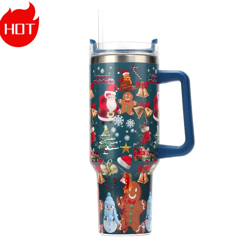 Tall insulated tumbler with blue handle, decorated with Christmas designs including Santa, gingerbread figures, and snowflakes, featuring a straw and a “HOT” label.