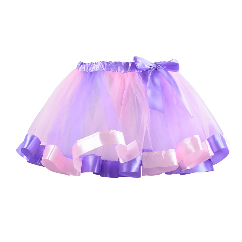 A pastel tutu skirt with layers of pink and purple tulle, featuring a satin ribbon bow and ruffled hem.