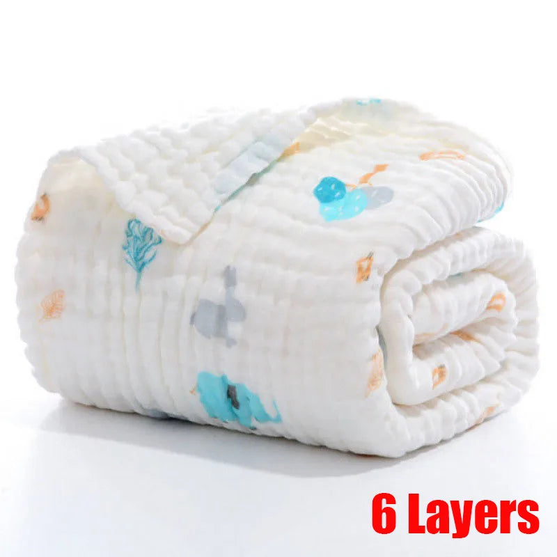 Rolled-up, 6-layered white muslin baby blanket with colorful animal and plant designs.