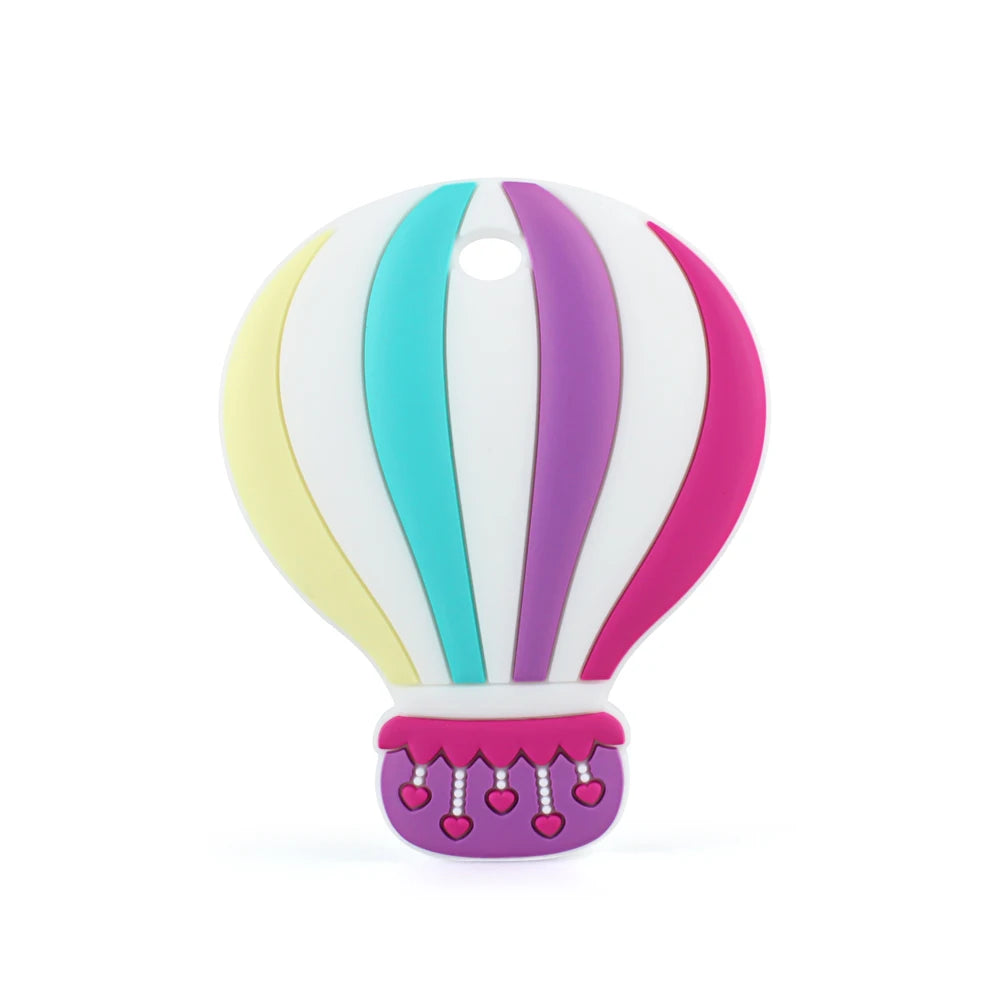 Colorful hot air balloon graphic with vertical pastel stripes in yellow, teal, white, purple, and pink. The basket has pink hearts and a decorative edge, with a hole at the top.