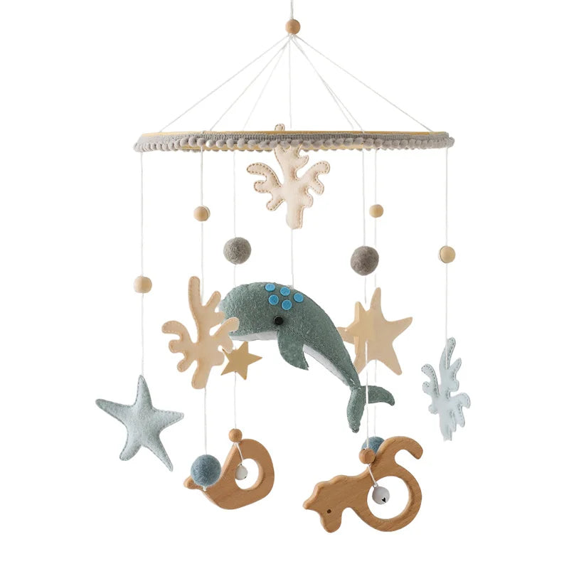 A whimsical mobile with felt and wooden sea creatures, including a dolphin, seahorse, and starfish, hanging from strings on a circular frame. Ideal for a nursery.