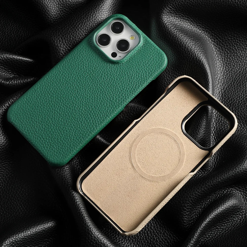 Two smartphone cases lie on black textured leather. One is green with a pebbled finish, displaying a phone’s camera, and the other is beige with a MagSafe ring imprint, showing its interior.