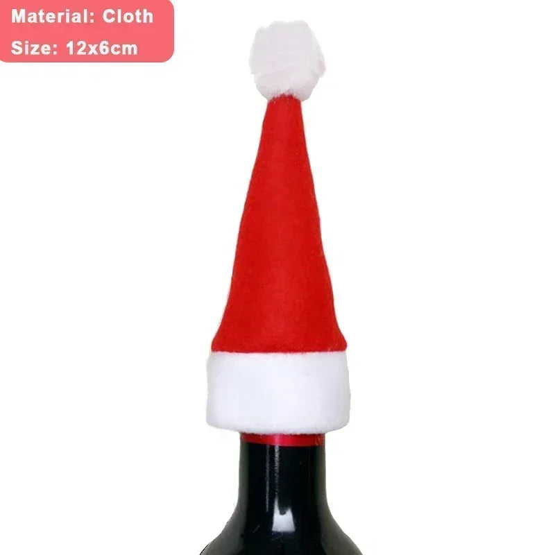 A red and white Santa hat made of cloth adorns the neck of a wine bottle. The hat is 12x6cm in size, with a white pom-pom on top.