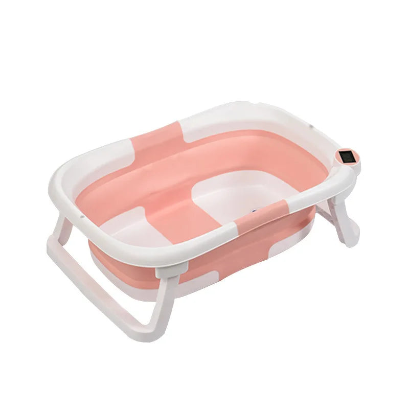 Collapsible pink and white baby bathtub with foldable legs, featuring a built-in digital thermometer on the rim.