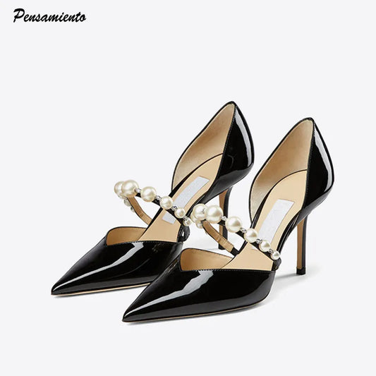 Elegant black patent leather high heels with pointed toes and pearl-embellished cross straps. The shoes have a sleek design, perfect for formal occasions.