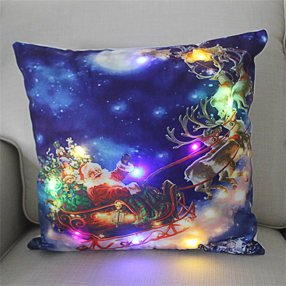Festive pillow featuring Santa in a sleigh with reindeer against a starry night sky. The pillow is adorned with colorful LED lights, creating a cheerful holiday scene.