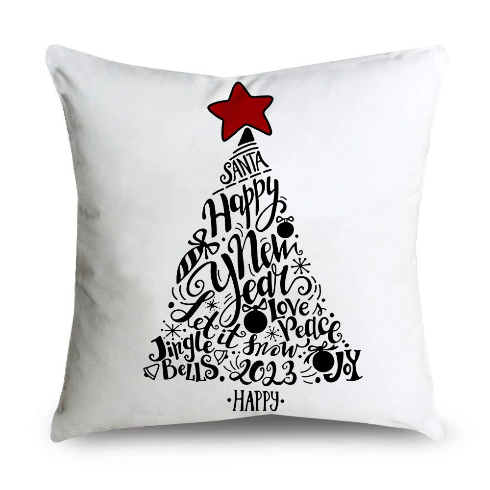 White cushion with a Christmas tree shape made of words like "Happy," "New Year," "Love," and "Joy" in black text. A red star tops the design.