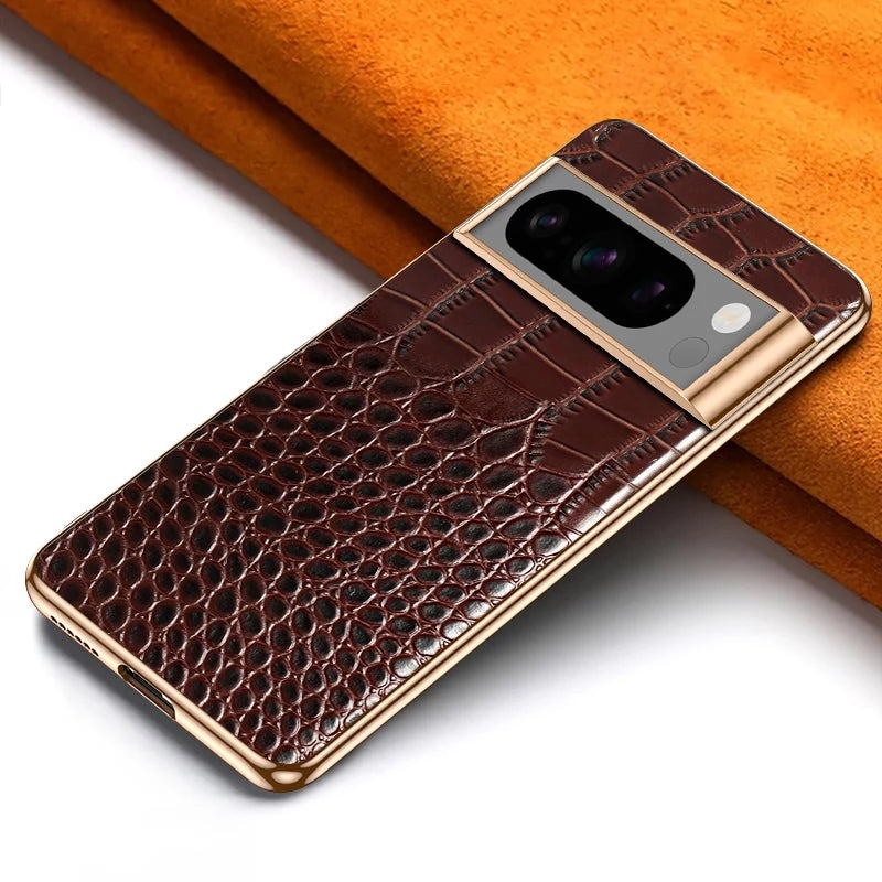Luxury smartphone with brown crocodile-textured leather case, featuring a gold-trimmed camera and sleek design, placed on an orange surface.