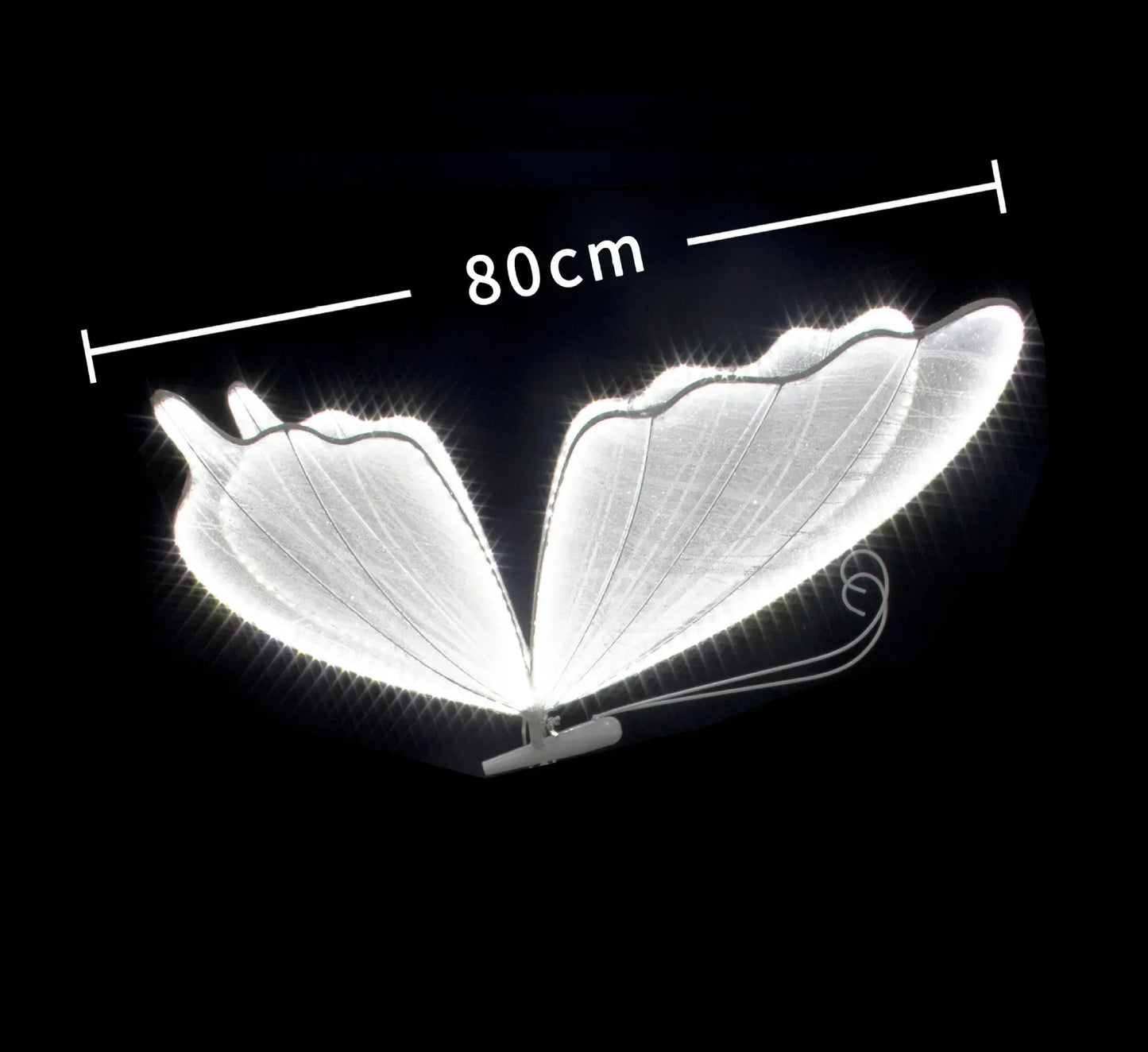 Illuminated, glowing butterfly wings measuring 80 cm, set against a dark background. The wings are elegantly designed with a delicate outline and visible texture.