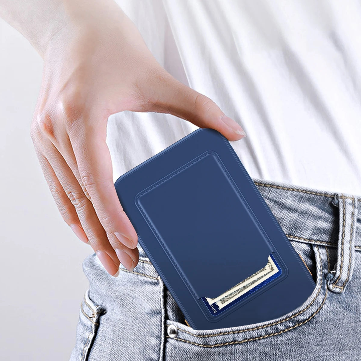 Hand placing a sleek blue wallet with card slots into the back pocket of jeans. The wallet partially reveals a credit card and a banknote, highlighting its slim design.