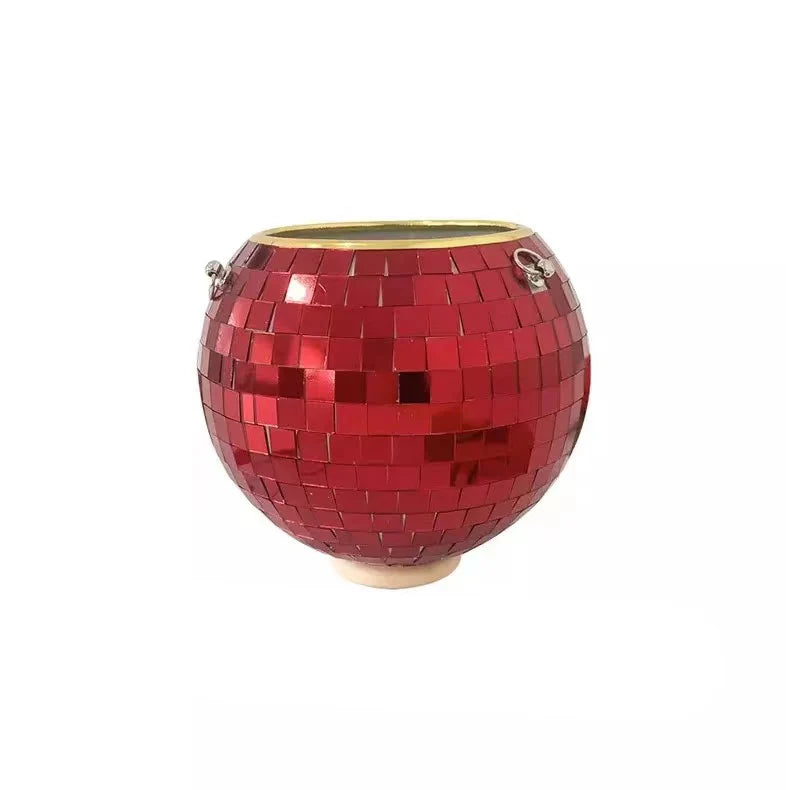 Red disco ball ice bucket with a shiny mosaic surface and small metal handles on either side, set on a neutral background.