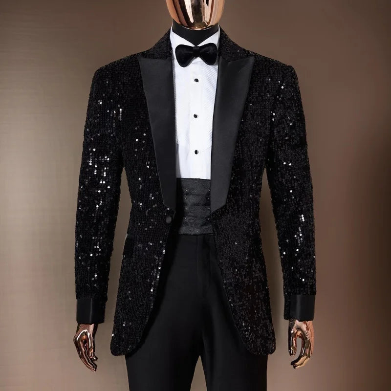 Mannequin wearing a black sequined tuxedo with satin lapels, a white dress shirt, black bow tie, and matching trousers, set against a simple brown background.