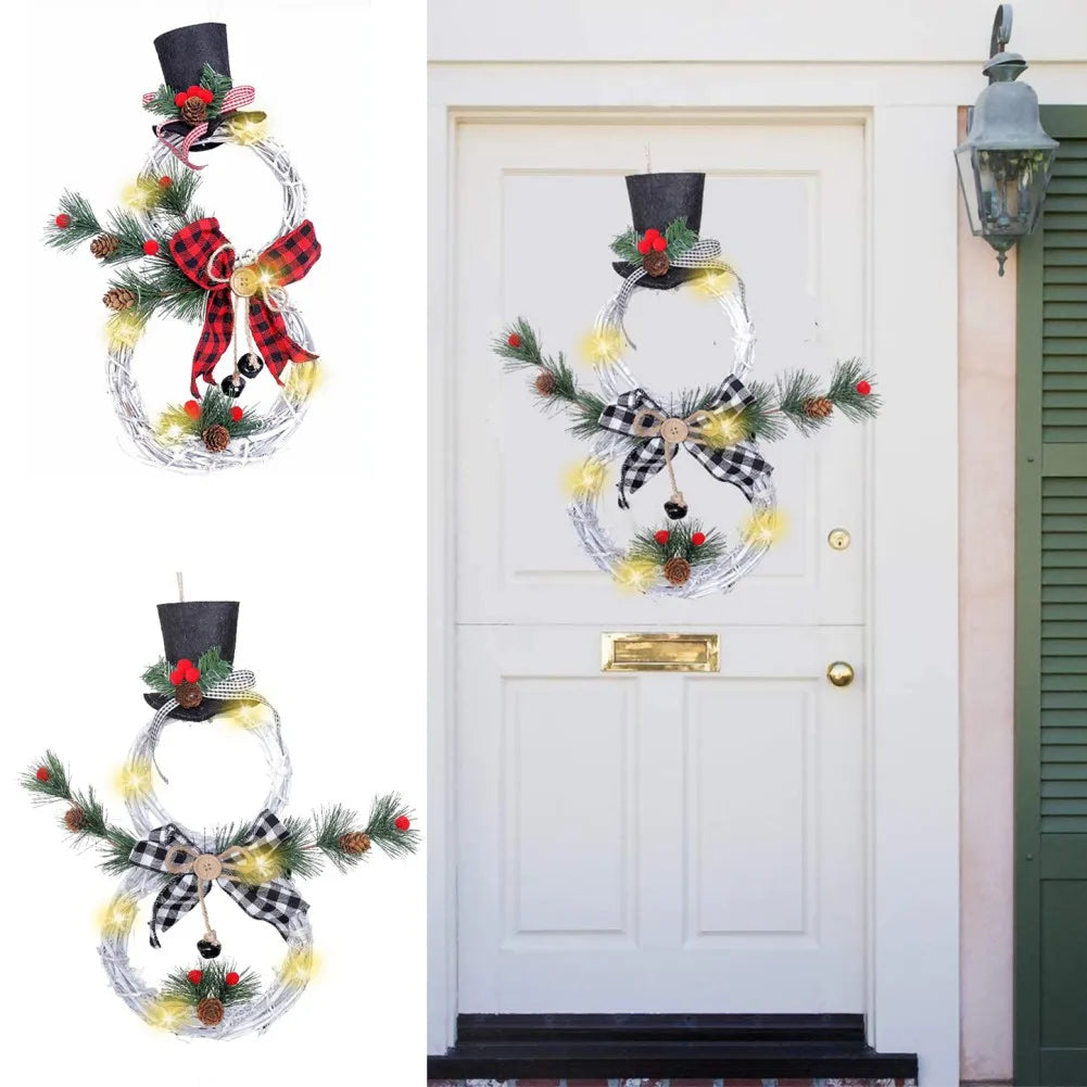 Wreaths shaped like snowmen with pine branches, berries, lights, and top hats adorn a white door. One features a red plaid bow, and another a black gingham bow.