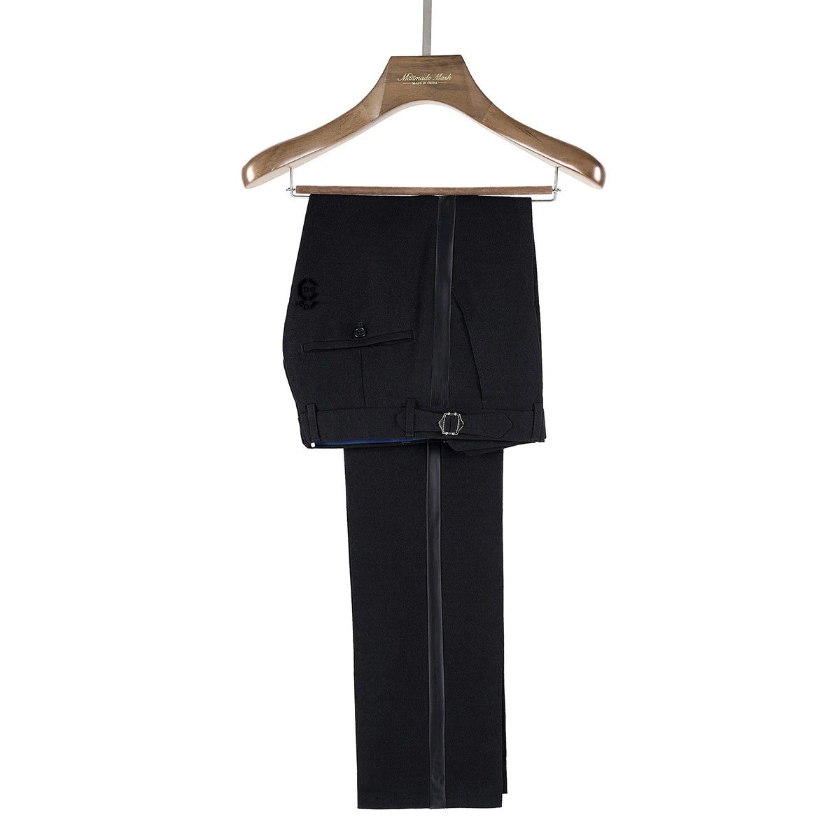 Black pants with double-button and buckle detail, neatly hung on a wooden hanger marked "Alexander Mark," set against a plain white background.