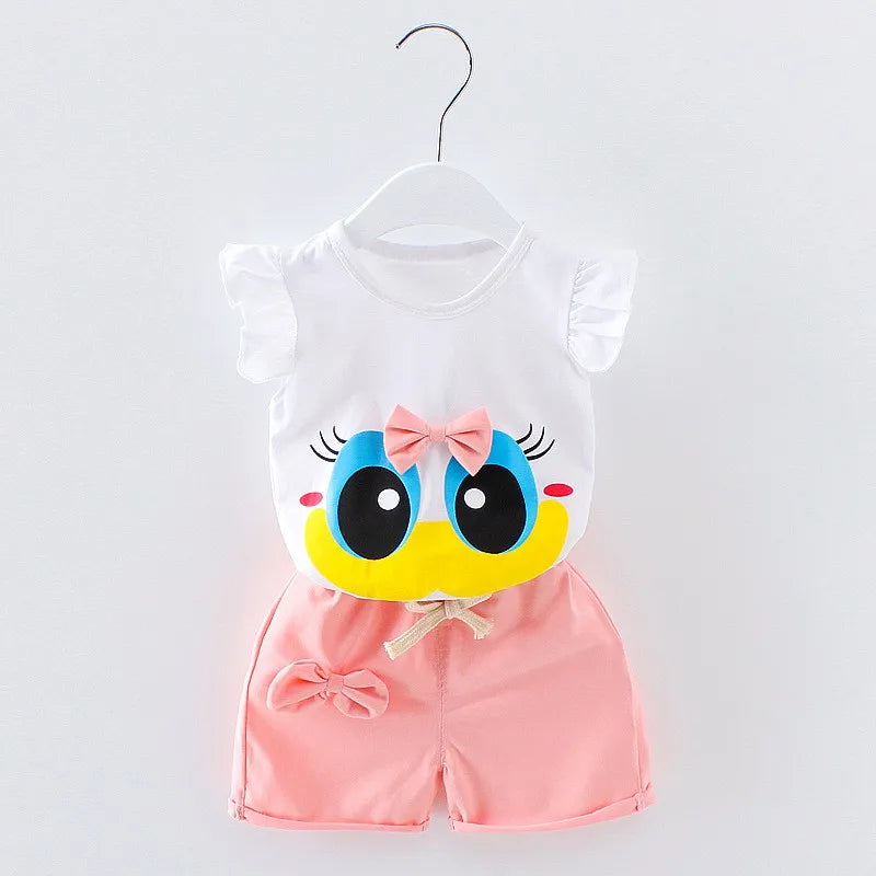 White and pink baby outfit on a hanger, featuring a ruffle-sleeved top with a cartoon duck face, blue eyes, and pink bow. Paired with pink shorts adorned with a bow.