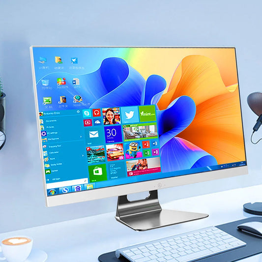 A modern desktop computer with a colorful screen displaying various apps and icons. The setup includes a keyboard, mouse, and a cup on a sleek white desk.