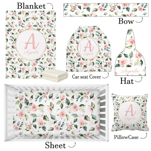 Floral baby set featuring a blanket, bow, car seat cover, hat, sheet, and pillowcase, all with a pink rose and green leaf pattern. Custom name and initial in pink.
