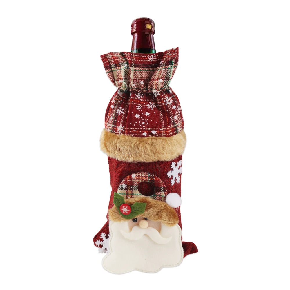 A wine bottle dressed in a festive red plaid and snowflake-patterned Santa-themed cover with a fur trim and plush Santa face, topped with a red bottle neck wrap.