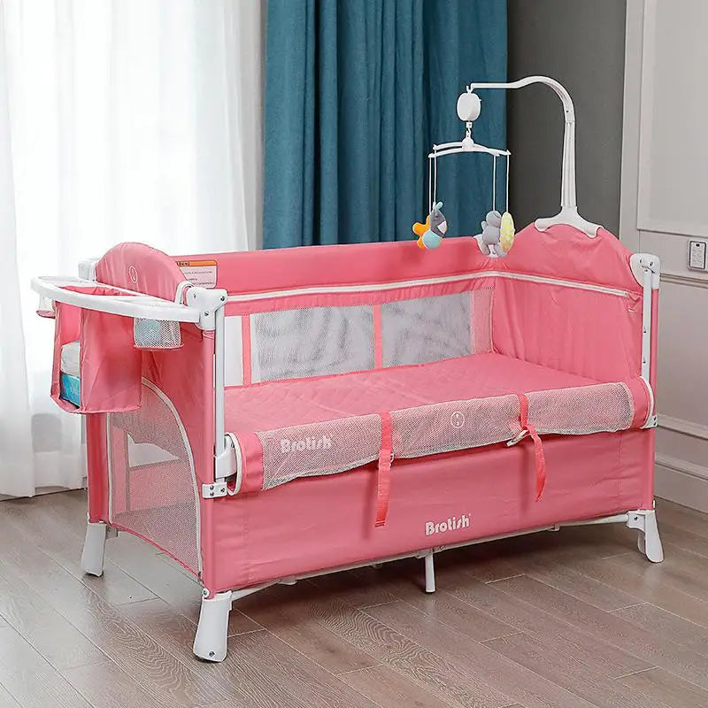 Pink baby crib with mesh sides, a side pocket, and a mobile featuring plush toys, set in a bright room with light curtains and a blue drape on wooden flooring.